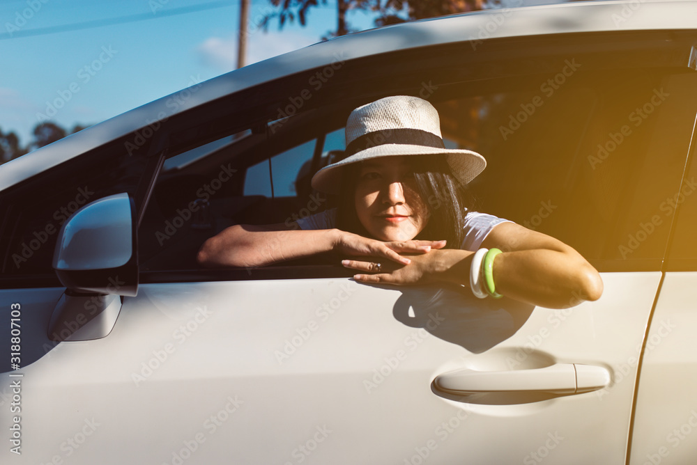Naklejka premium Happy asian woman sitting in new car on road,Relax and free time,Positive thinking