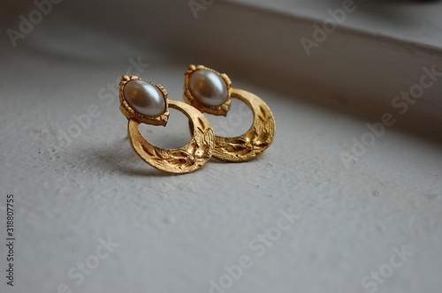 Close-Up Of Gold Earrings On Table Fototapet