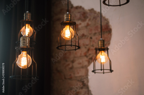 black metal lamps in the loft style in a dark room against the background of an old battered wall, one object in focus the rest are blurred