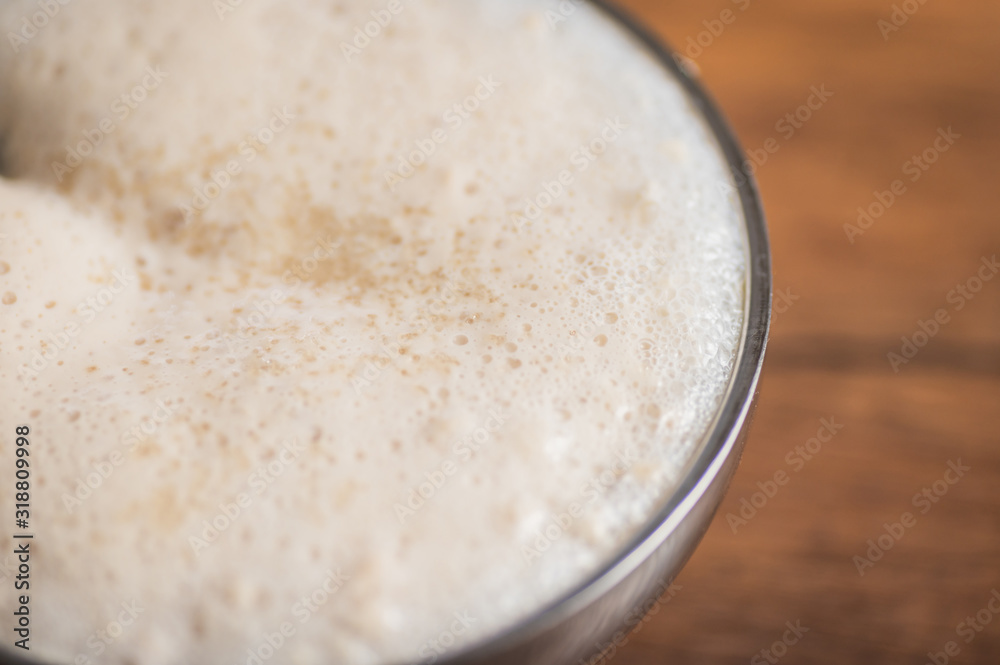 Close up of yeast starter foaming in a container. Close up of yeast starter foaming in a container.