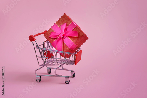 Happy Valentine's Day. Mini trolley from the supermarket, heart souvenir, 14, 2. Design for pink background, space for copying. Postcard, booklet. Discounts, sale. Black Friday!