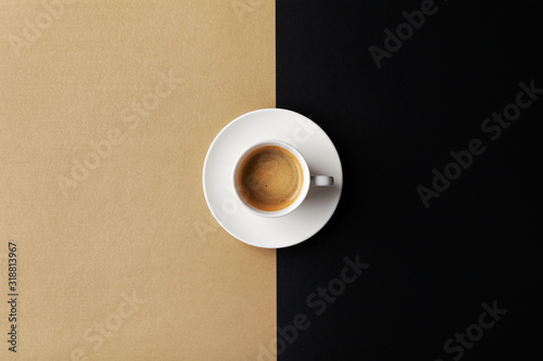Filiżanka kawy na złocistym czarnym tle. Minimalistyczne płaskie ułożenie. Widok z góry.