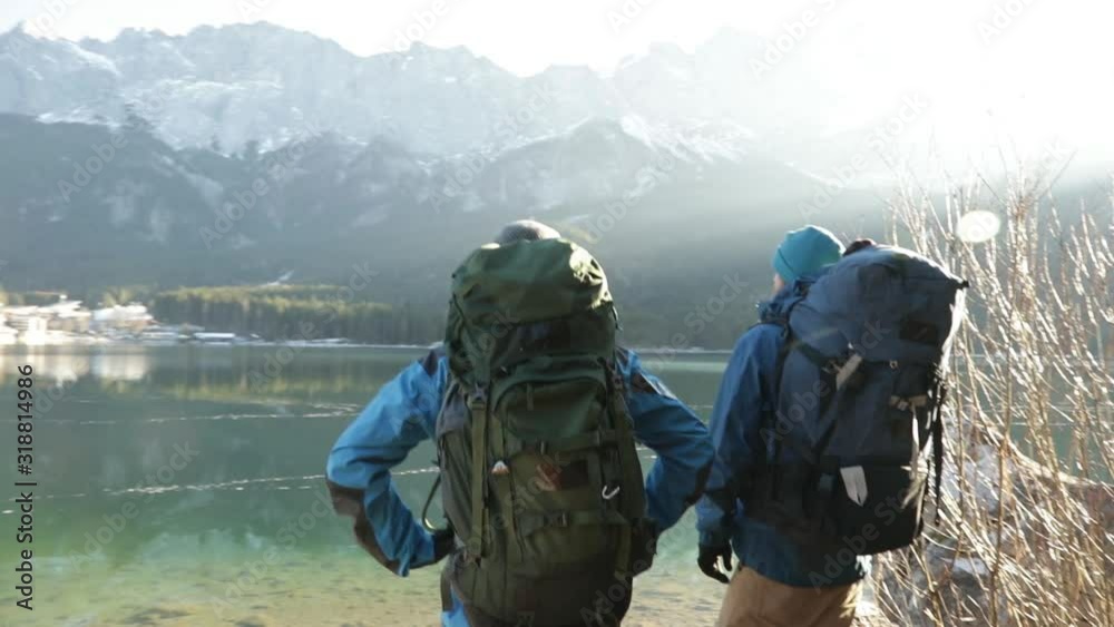 Real time shot of two hikers enjoying lake view, Bavaria, Germany Real time shot of two hikers enjoying lake view, Bavaria, Germany