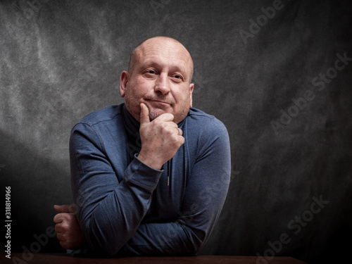 Fotografija portrait of a middle-aged man on a dark background. reverie