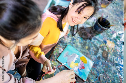 Happy asian child girl enjoy paint,family activities having fun,relax with her mother,smiling daughter,woman use watercolor with palette,paintbrush to painting,study,learn the art,development concept