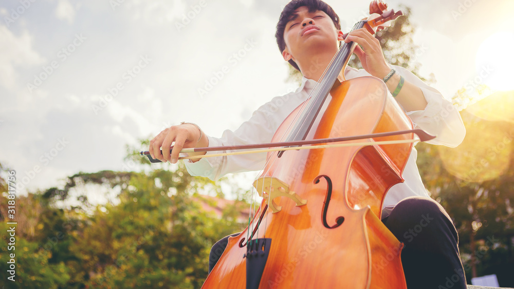 A musician man is practicing the cello playing with the melodiousness. Selected focus.