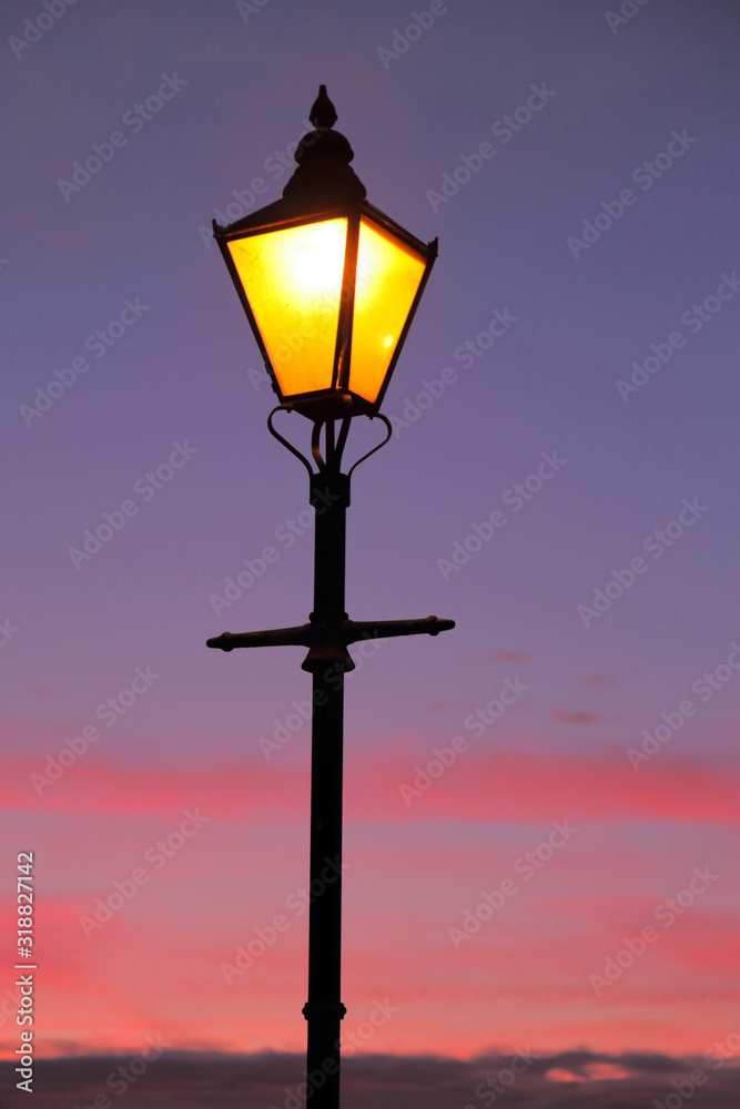 Lamppost against colorful sky at dawn