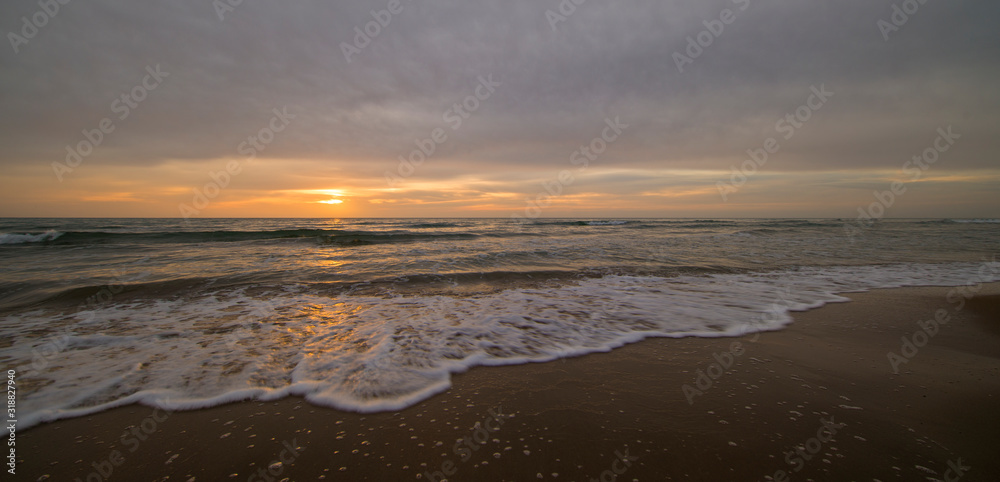 A calm and cloudy sunrise on the beach