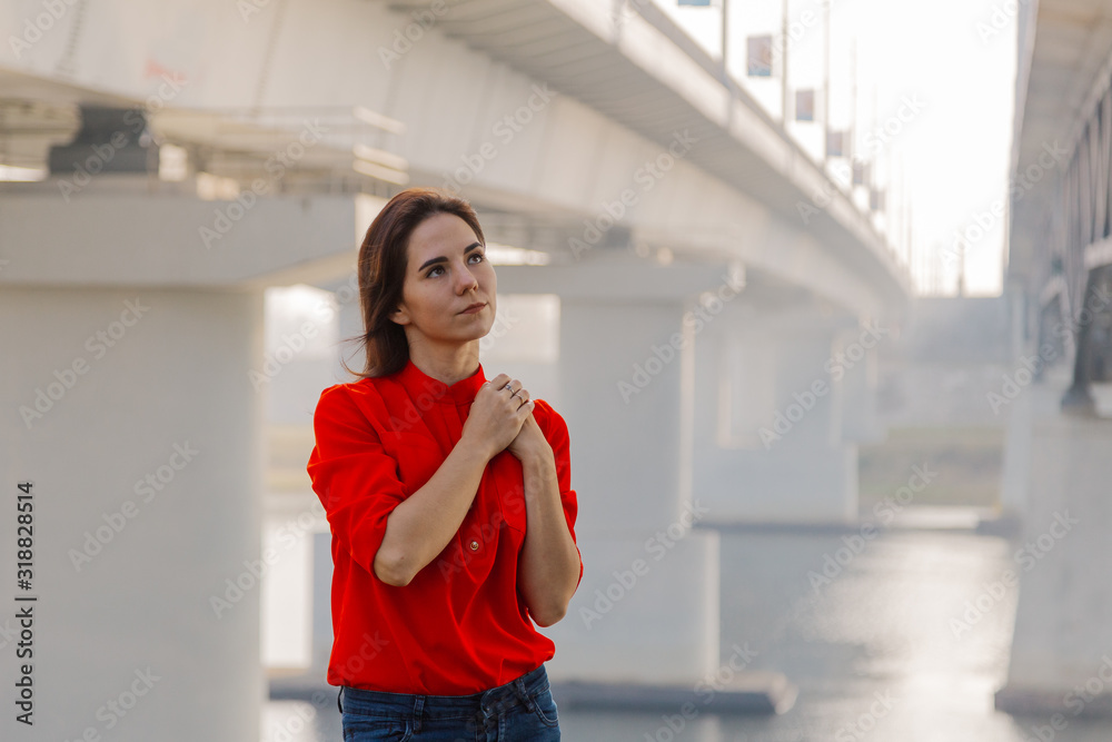 Beautiful girl stands at the bridge near the river. Beautiful girl stands at the bridge near the river.