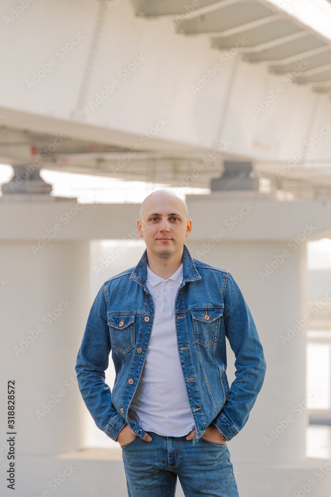 Handsome stylish man stands at the bridge near the river. Handsome stylish man stands at the bridge near the river.