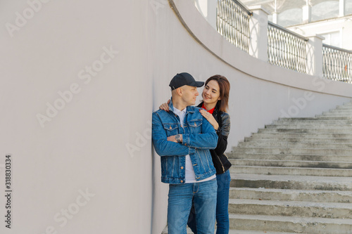 Happy lovers hug on a concrete staircase. © combo1982