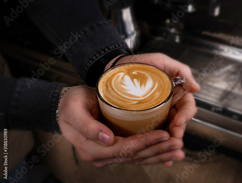 Barista makes latte coffee with milk in cafe closeup