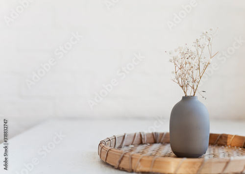 small vase and white flowers on a table near the window