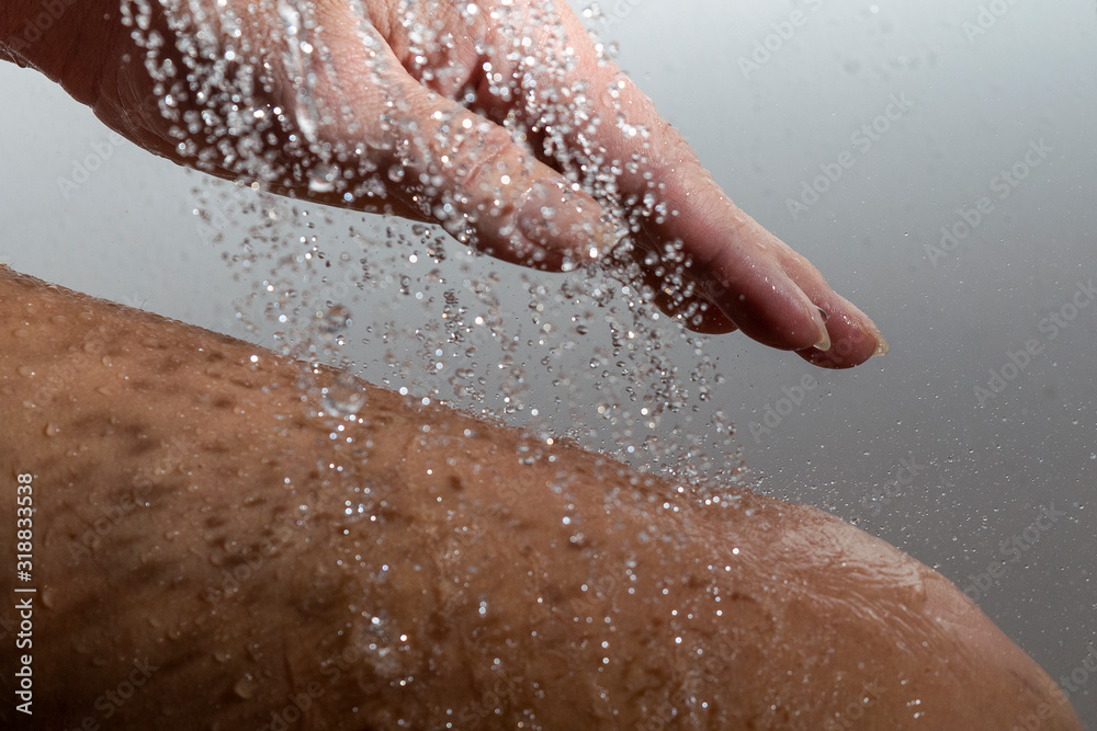 Fototapeta premium Falling water drops and human hand.