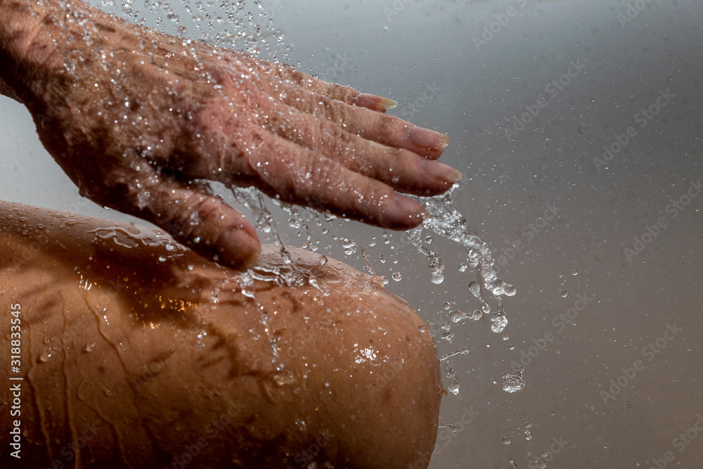 Fototapeta premium Falling water drops and human hand.