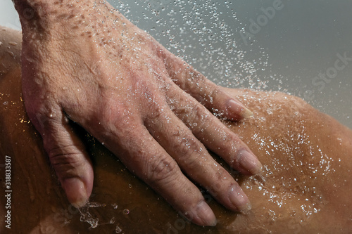Falling water drops and human hand.