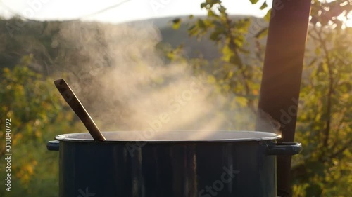 Water evaporation from big iron cauldron slow motion footage photo