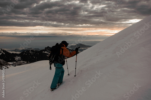 Male traveller hikes up the snowy mountain