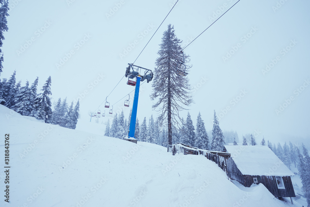 Ski lift with seats going over the mountain and paths from skies and snowboards. Ski lift with seats going over the mountain and paths from skies and snowboards.