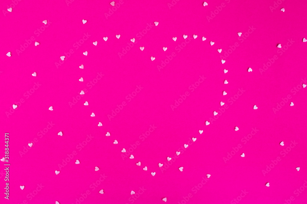 Bright pink background. Pink hearts on a pink background. Hearts sprinkles. Valentine day. Flat lay style. Top view. Place for design. Sweet background. Confetti.