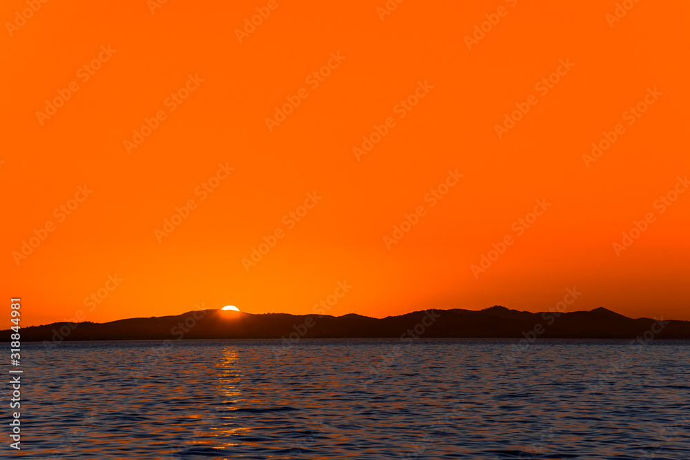 Background with landscape of sunset over sea, view from beach in Zadar, Dalmatia, Croatia Background with landscape of sunset over sea, view from beach in Zadar, Dalmatia, Croatia