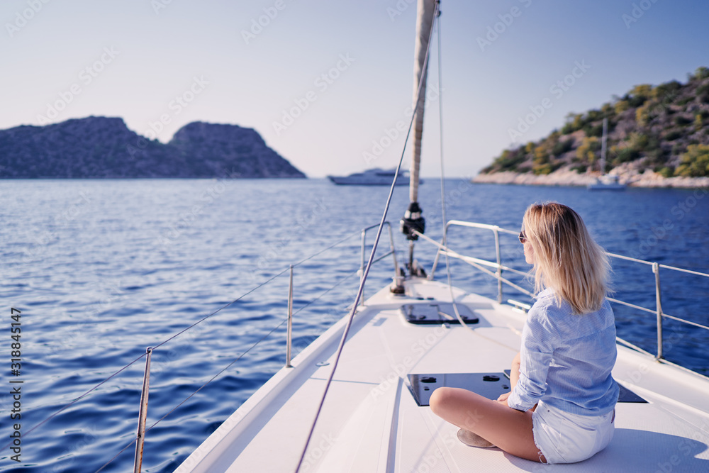 Luxury travel on the yacht. Young happy woman on boat deck sailing the sea. Yachting in Greece. Luxury travel on the yacht. Young happy woman on boat deck sailing the sea. Yachting in Greece.