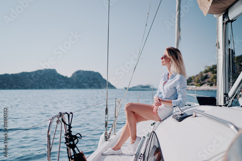 Luxury travel on the yacht. Young happy woman on boat deck sailing the sea. Yachting in Greece.