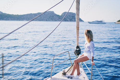 Luxury travel on the yacht. Young happy woman on boat deck sailing the sea. Yachting in Greece. © luengo_ua