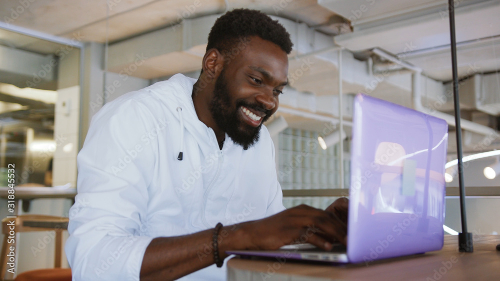 Satisfied handsome young african american man working use computer look camera monitor screen office technology businessman casual communication successful person portrait smart business slow motion Satisfied handsome young african american man working use computer look camera monitor screen office technology businessman casual communication successful person portrait smart business slow motion