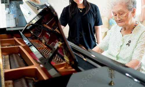 Senior elder woman plays piano