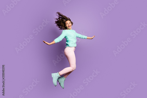 Full body photo of funny cheerful girl jump enjoy rest relax free time scream wear pastel pink teal shoes sweater isolated over violet color background