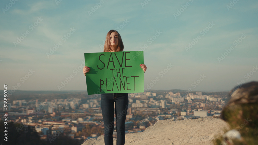 Young woman activist holding encouraging green poster Save the Planet ...