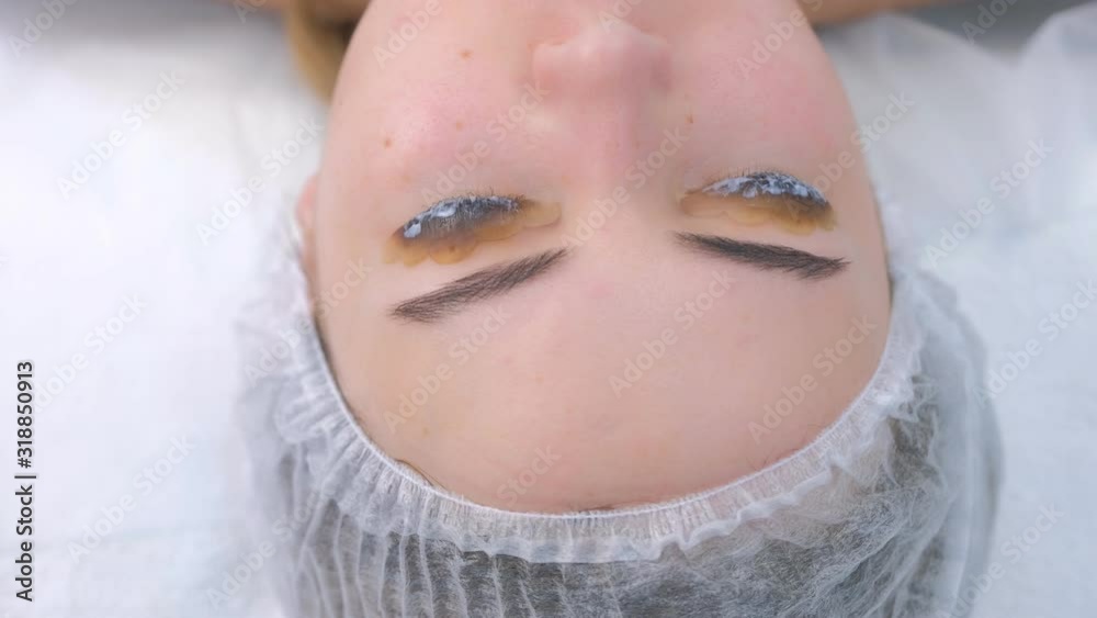 Woman with solution for lamination on lashes, lift eyelashes procedure, closeup eyes. Making lash lifting in cosmetology clinic. Beauty industry concept. Woman with solution for lamination on lashes, lift eyelashes procedure, closeup eyes. Making lash lifting in cosmetology clinic. Beauty industry concept.