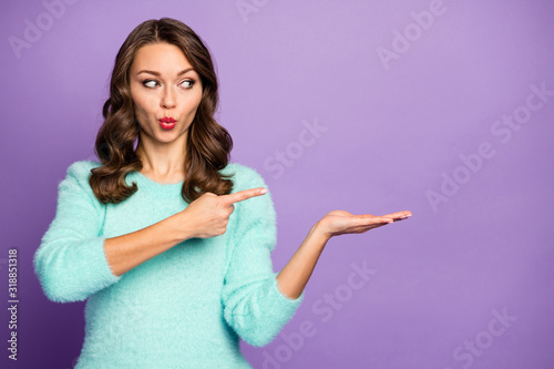 Photo of pretty socked wavy lady hold open arm advising novelty product indicating finger cool low price wear casual teal fluffy sweater isolated purple pastel color background