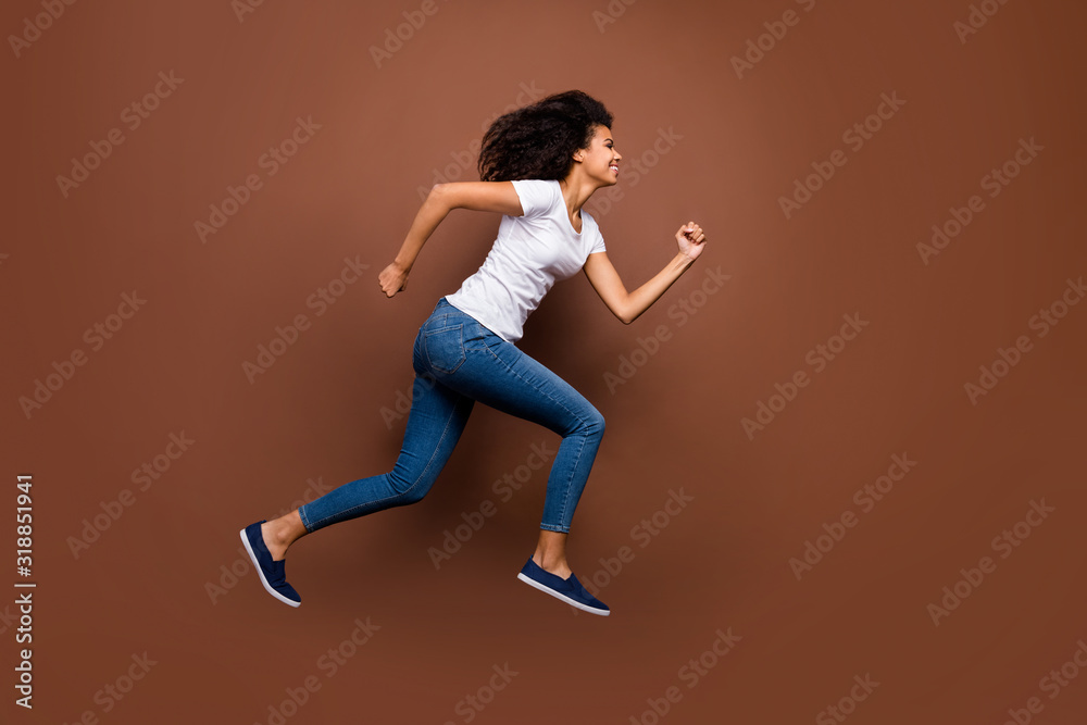 Full body profile photo of crazy funny dark skin lady jumping high sportive competitions participant rushing finish wear white t-shirt jeans isolated brown color background