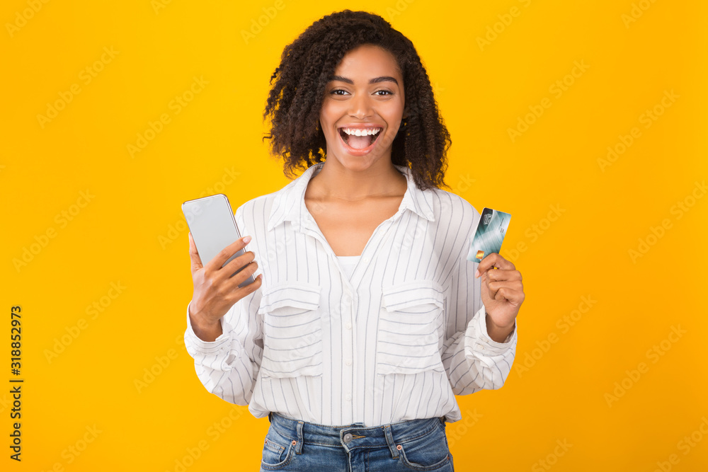 Black woman holding credit card and mobile phone Stock Photo Adobe Stock