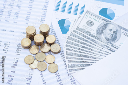 Stack of coins and dollar banknote on blue pastel chart paper. Business, finance, marketing, e-commerce concept and design.