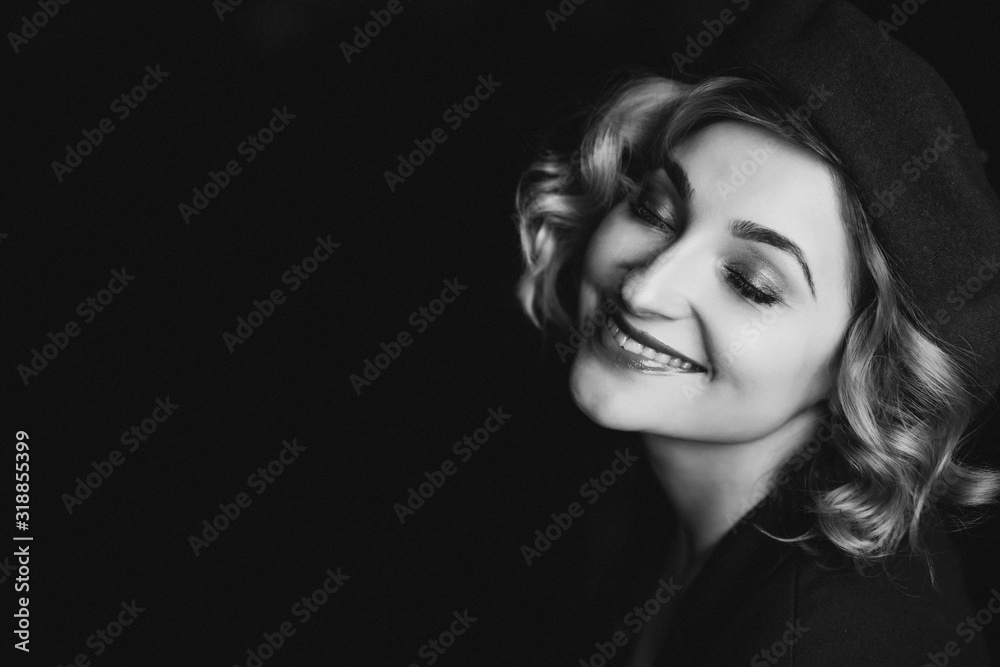 Beautiful blonde woman in a beret closed her eyes and smiles in retro style black and white photo. Close-up portrait. Soft focus.