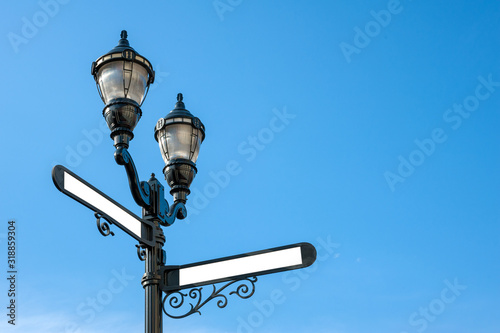Antique iron streetlight with blank street names on the crossroads in Hoboken, New Jersey, USA