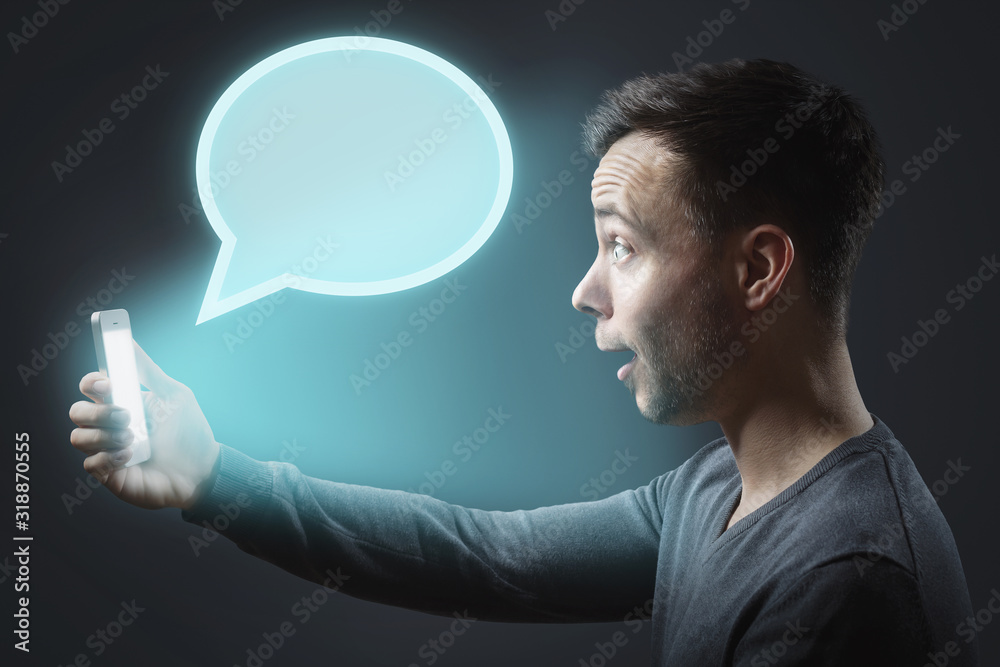 Astonished man getting a message on his smartphone Astonished man getting a message on his smartphone