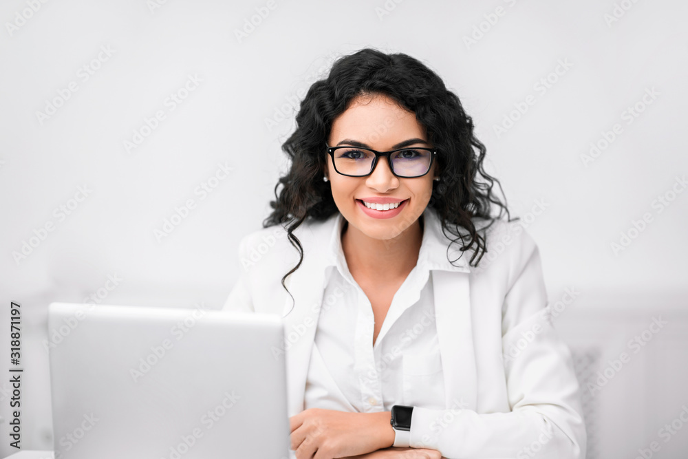 Happy hispanic manager smiling at camera in office Happy hispanic manager smiling at camera in office