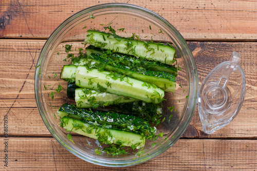 Step by step cooking pickled cucumbers with dill and garlic, step 4 - adding vegetable oil and mixing the ingredients, top view, selective focus