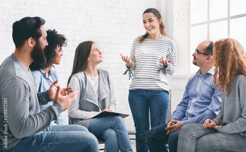 Woman sharing her progres with group on therapy session in rehab photo