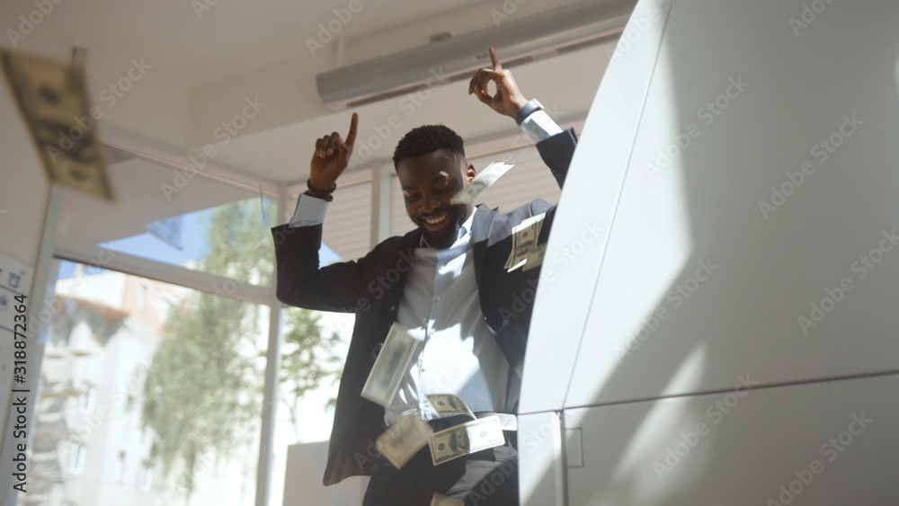 Nice-looking successful businessman taking money from credit card using an ATM machine. Handsome bank client holding a credit card looking at camera indoors. Nice-looking successful businessman taking money from credit card using an ATM machine. Handsome bank client holding a credit card looking at camera indoors.