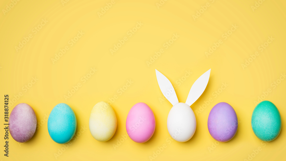 Easter colorful flat lay with eggs row and bunny egg Easter colorful flat lay with eggs row and bunny egg