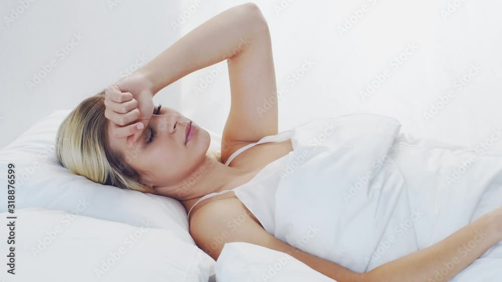 Young woman lying in the bed. Beautiful blond sleeping girl. Morning in the bedroom. Health and rest concept. Young woman lying in the bed. Beautiful blond sleeping girl. Morning in the bedroom. Health and rest concept.