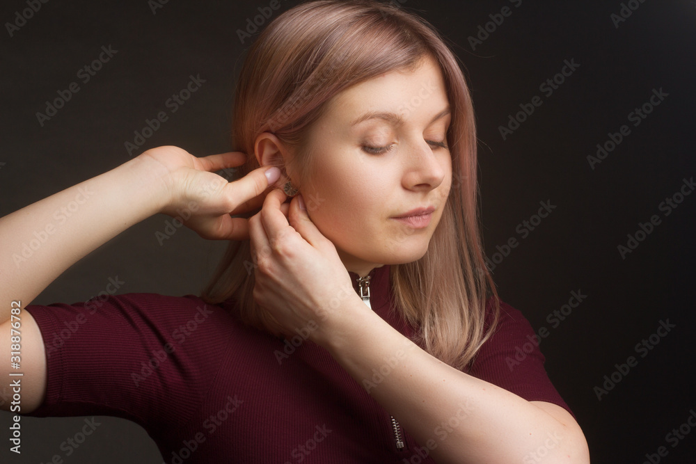 Obraz premium Portrait of the blonde in the red sweater with short sleeves. Studio shot on dark gray background