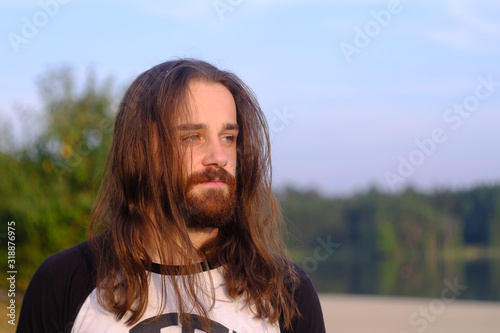 Portrait of handsome bearded young man with long hair