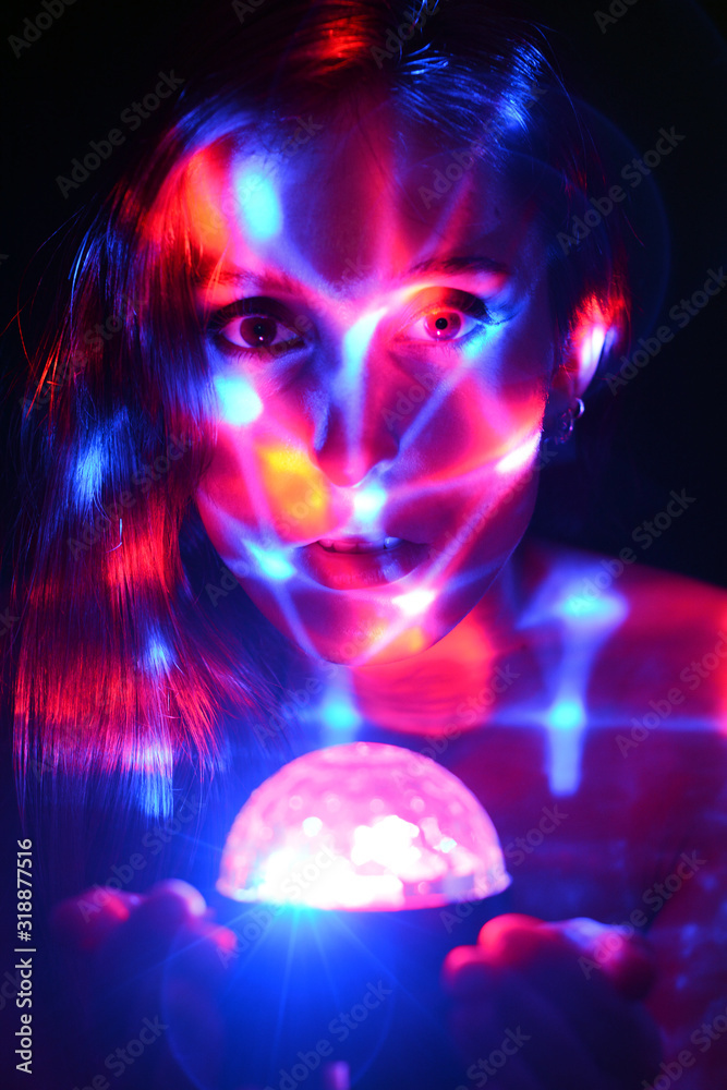 Young woman in studio with artistic colorful projection from disco light