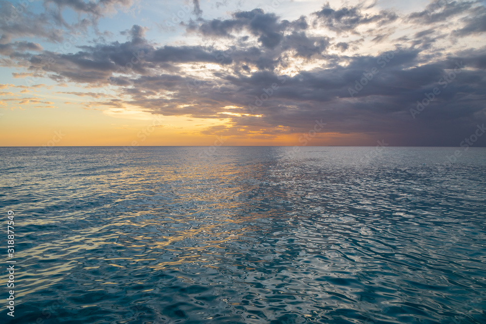 Beautiful sunset on the Caribbean, bright orange sun in the clouds.